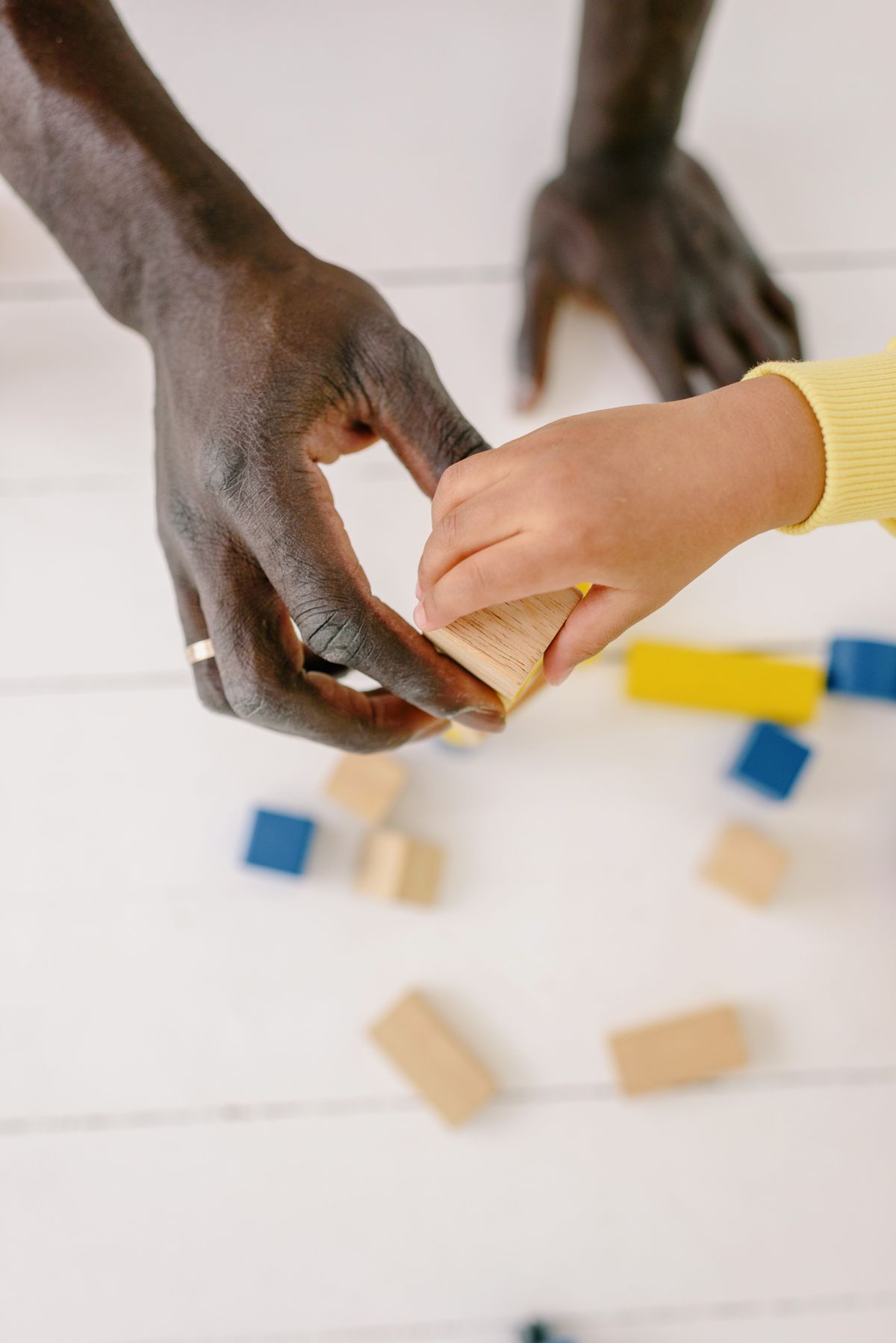 An adult and child exploring wooden blocks together